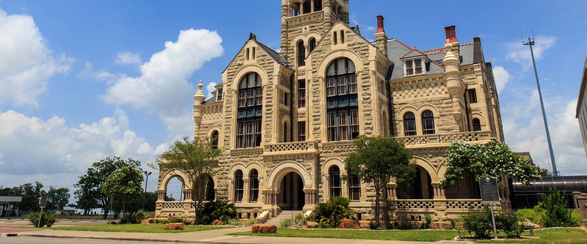The Historical old Victoria County Courthouse built in 1892 looks like a castle. It stands next to De Leon Plaza on the main square in Victoria, Texas.