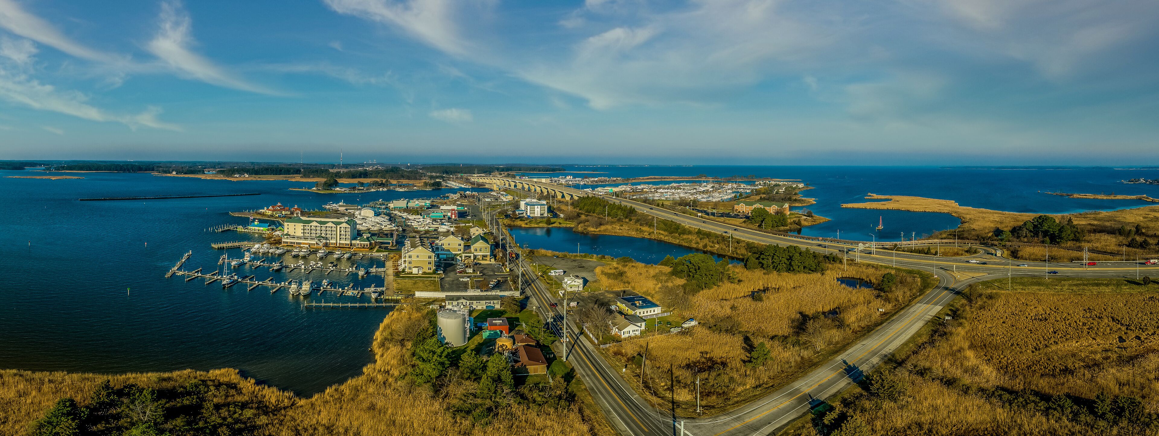 A coastal town with a marina, a bridge, and a highway.