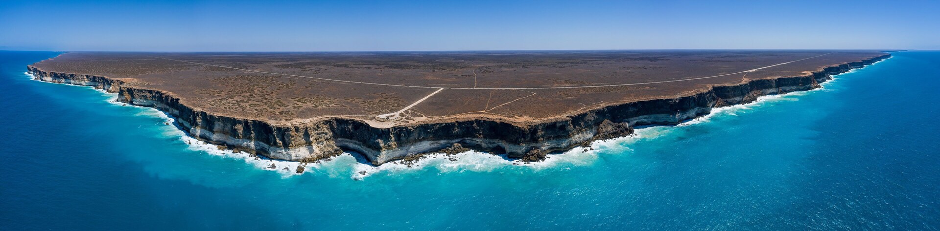 A coastal cliff with a road running along its edge.