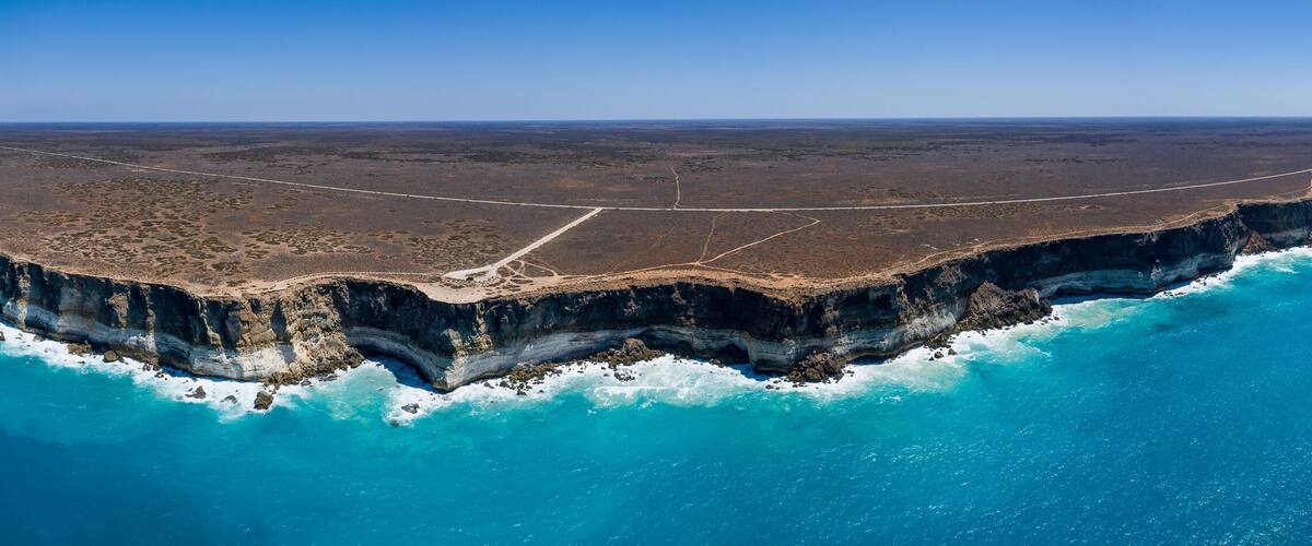 A coastal cliff with a road running along its edge.