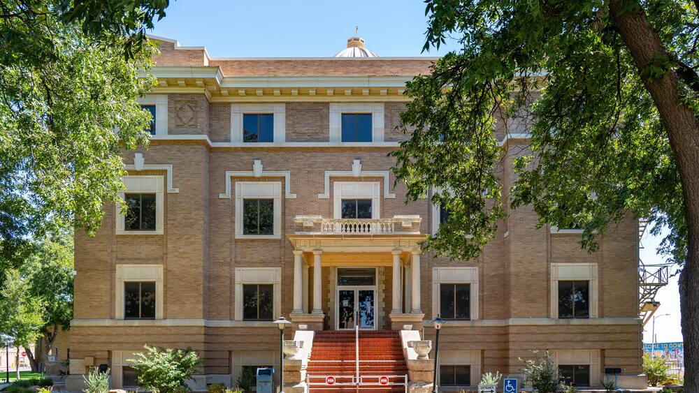 A historic building with a central entrance, large windows, and a brick facade.
