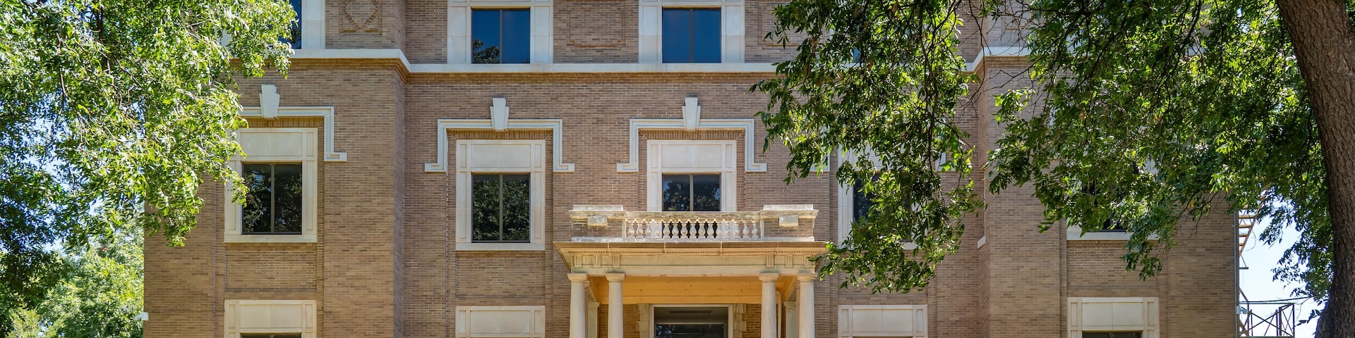 A historic building with a central entrance, large windows, and a brick facade.