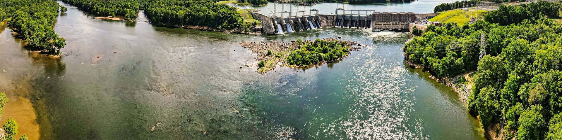 An aerial 180 degree panoramic view of a large dam and hydroelectric plant on the Catawba river in South Carolina and Lake Wylie in the background.