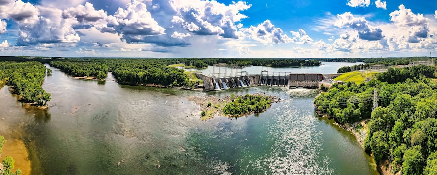 An aerial 180 degree panoramic view of a large dam and hydroelectric plant on the Catawba river in South Carolina and Lake Wylie in the background.
