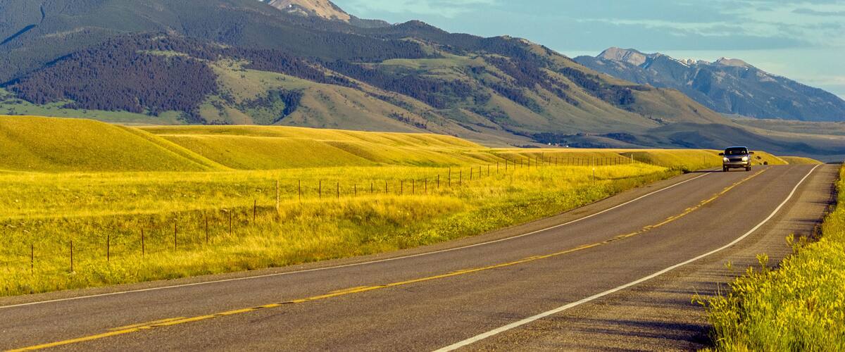 Local road through the meadows of sunny Montana landscape, USA