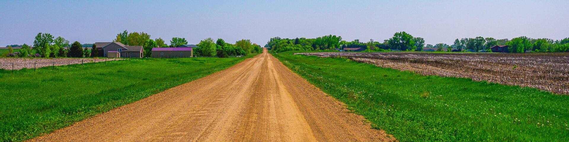 Dirt road, horizon, and the big sky: Tranquil midwestern farmland summer landscape in Hartford, Minnehaha County, South Dakota