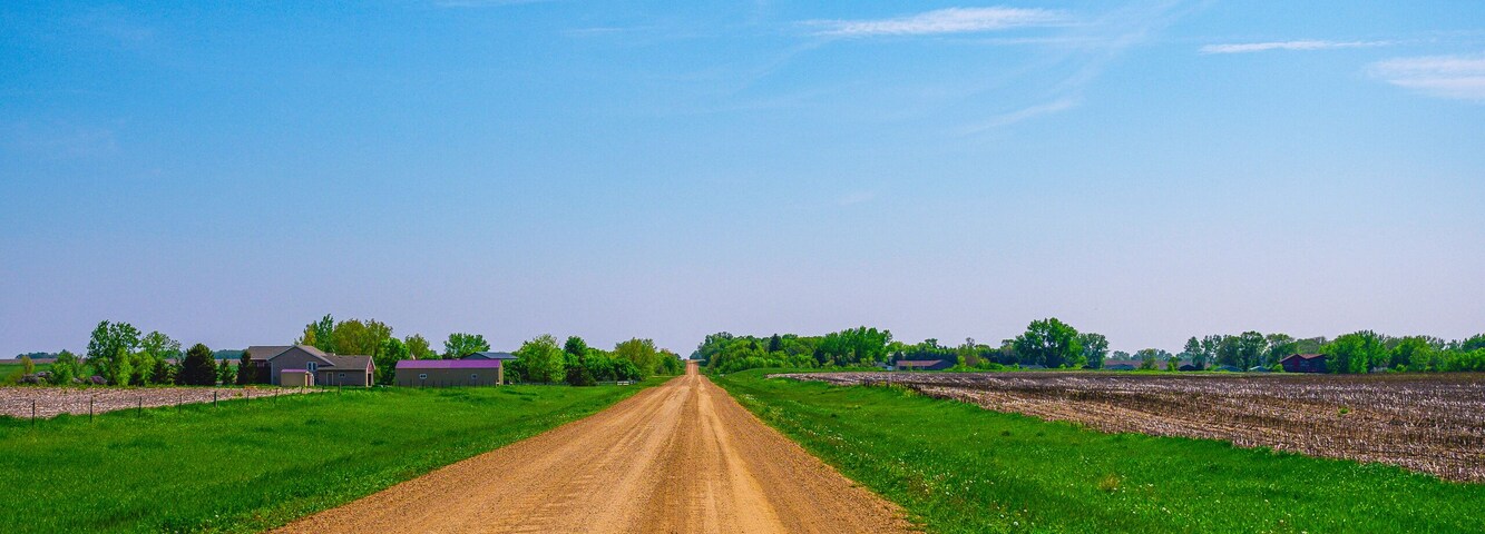 Dirt road, horizon, and the big sky: Tranquil midwestern farmland summer landscape in Hartford, Minnehaha County, South Dakota
