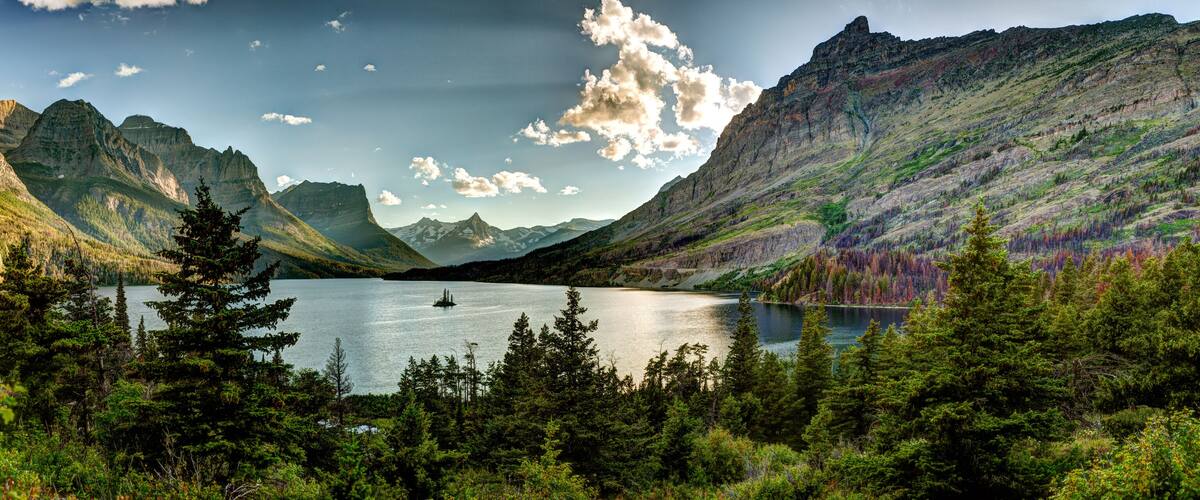 A mountainous landscape with a lake and forested area.