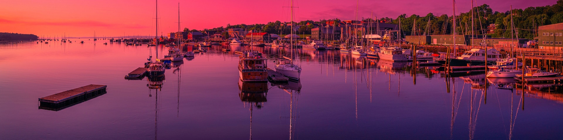Belfast Harbor at Twilight in Maine. Saturated vibrant and tranquil marina landscape at dawn with moored recreational and commercial boats and ships.