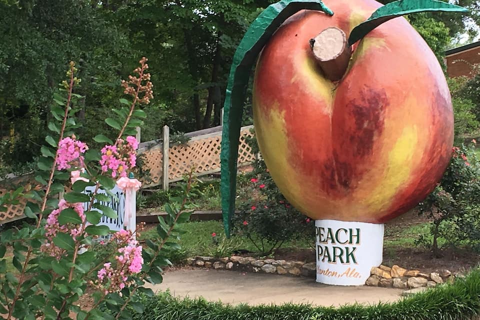 Una gran escultura de melocotón con un letrero que dice "Peach Park" en Winton, Alabama.
