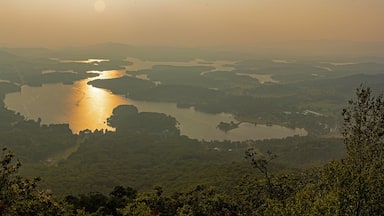A river winding through a valley with surrounding hills and dense vegetation.