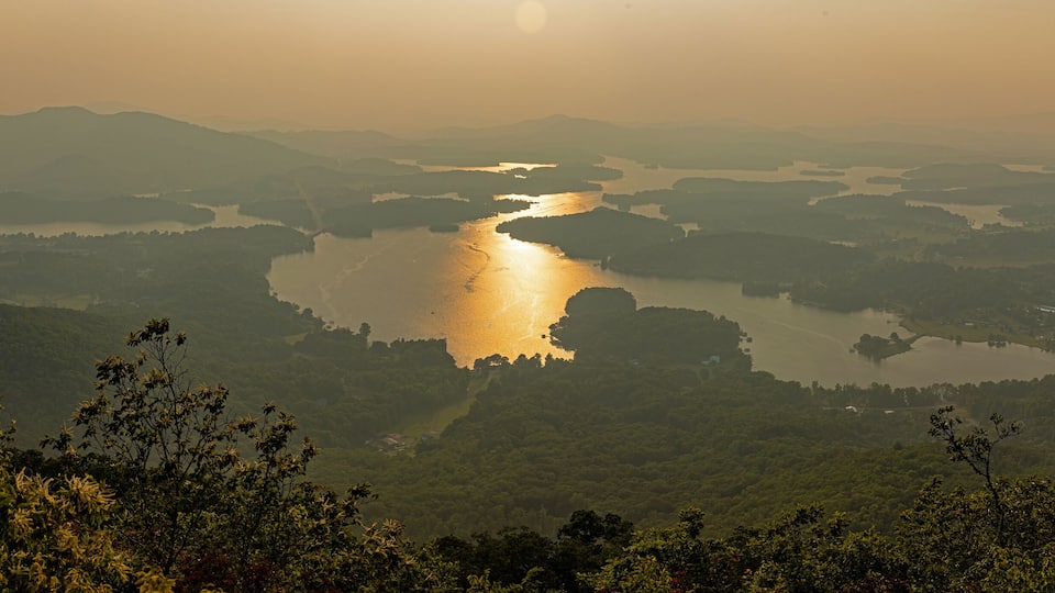 A river winding through a valley with surrounding hills and dense vegetation.