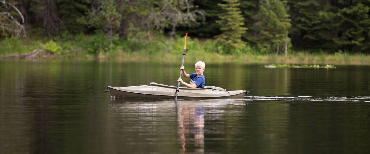 Boy kayaking on Moose Creek Reservoir in northern Idaho