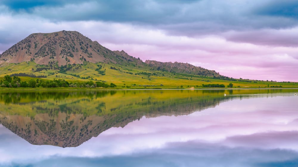 Bear Butte, or Paha Sapa in Lakota language for Black Hills, reflected on the Bear Butte Lake in Sturgis, South Dakota, United States: Black Hills Country Summer Landscape
