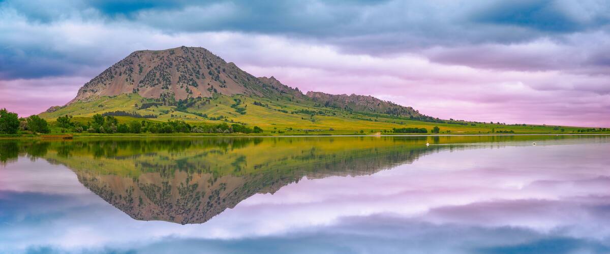 Bear Butte, or Paha Sapa in Lakota language for Black Hills, reflected on the Bear Butte Lake in Sturgis, South Dakota, United States: Black Hills Country Summer Landscape