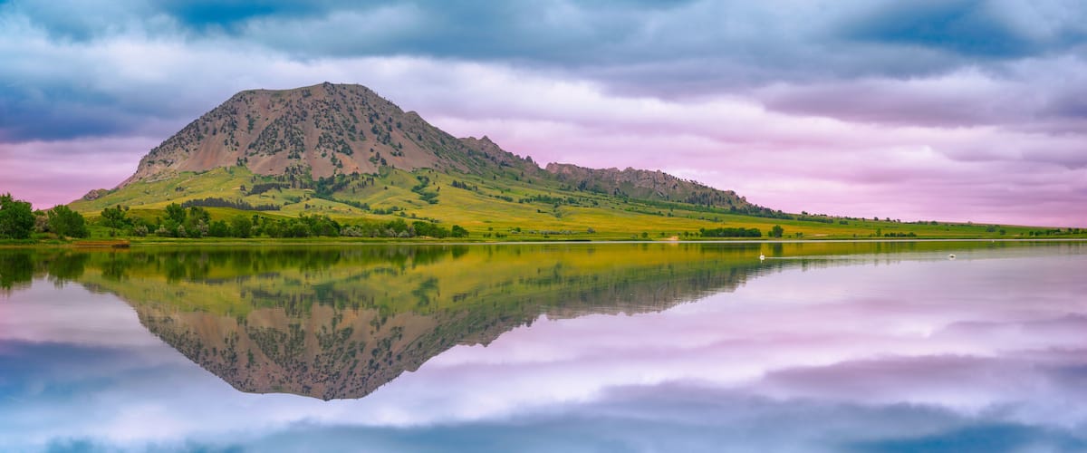 A mountain reflected in a calm lake with a cloudy sky.