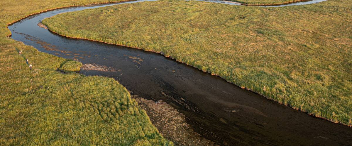 River winding through open field during late summer in Montana.