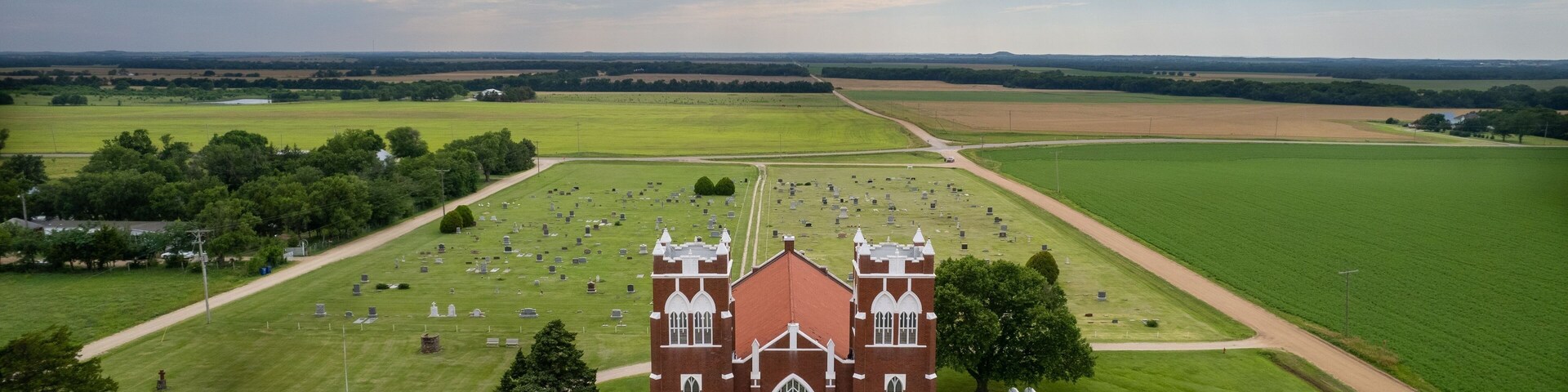 Aerial view of Salemsborg Lutheran Church in a green field near a cemetery in Saline County, Kansas