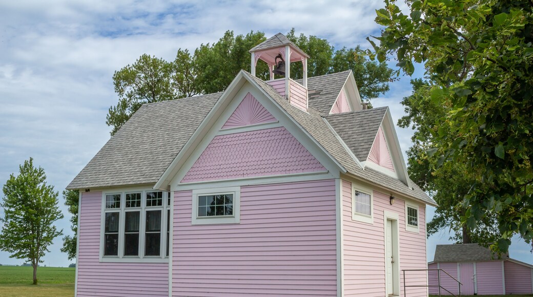 Close up view of an old pink country school house exterior with bell tower, built in the 1800’s in the midwestern USA