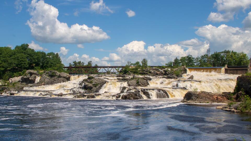 A river with a waterfall, a bridge, and a dam.
