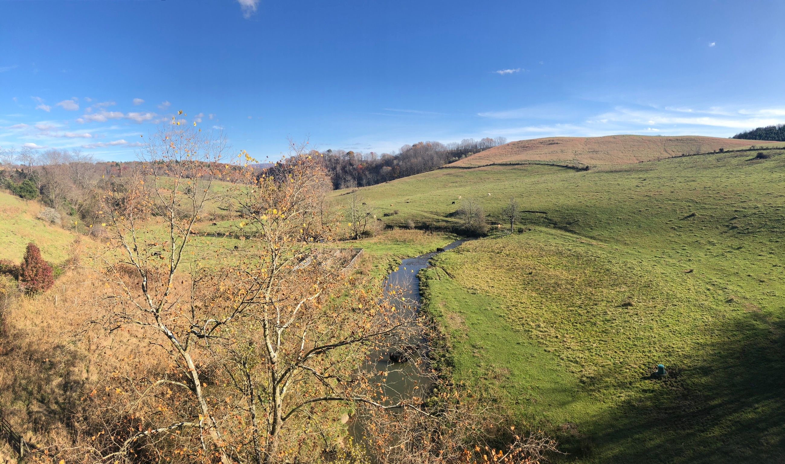 A river winding through a hilly landscape with autumn foliage.