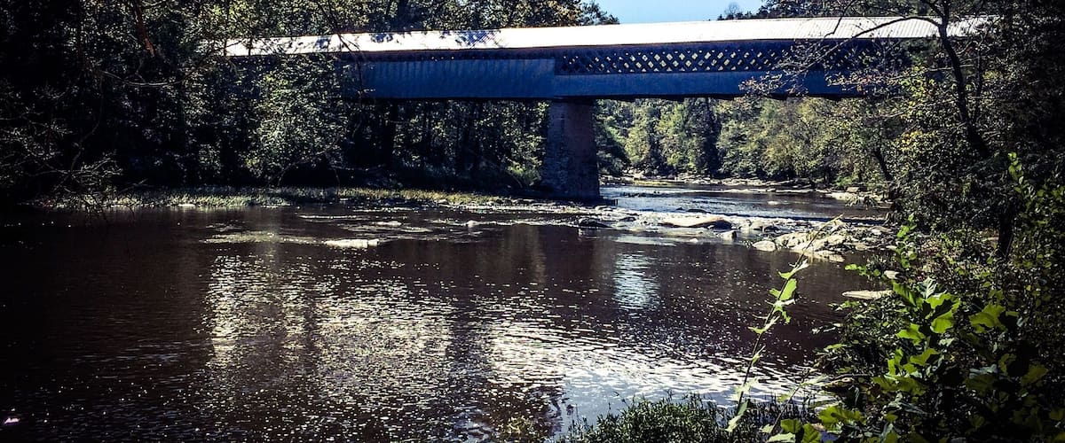 A bridge over a river surrounded by trees.