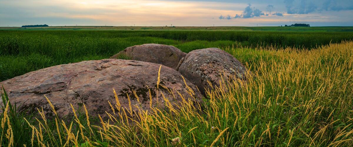 Tranquil sunset landscape over the prairie with glacial rocks in Big Stone National Wildlife Refuge in Odessa, Minnesota, USA