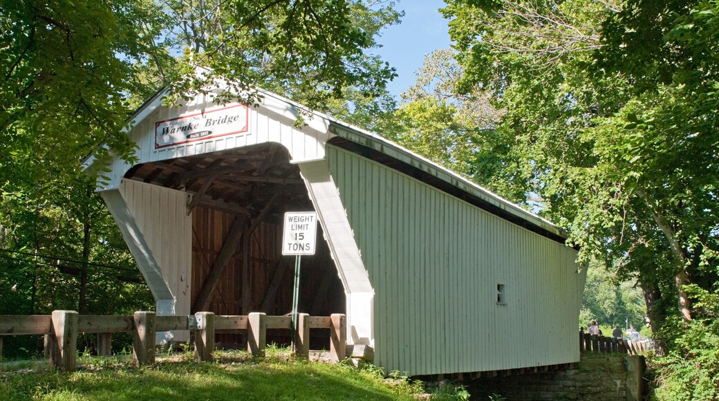 A covered bridge with a sign indicating a weight limit of 15 tons.