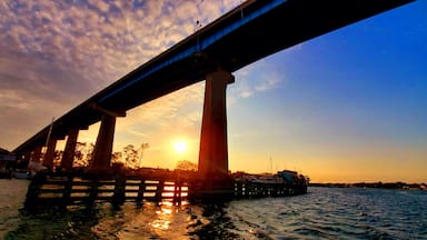 Uma ponte ao pôr do sol, com o sol se pondo atrás dela.