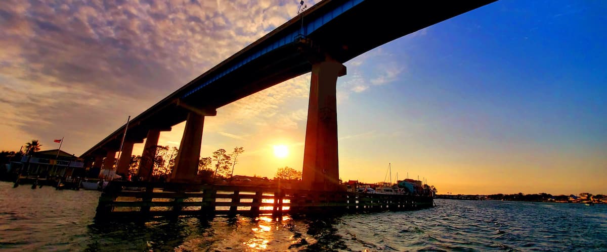 A bridge at sunset with the sun setting behind it.