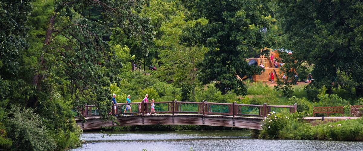 Family Walking Across Scenic Bridge