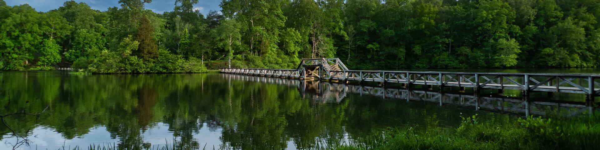 Foot bridge over the lake with reflections, stormy sky