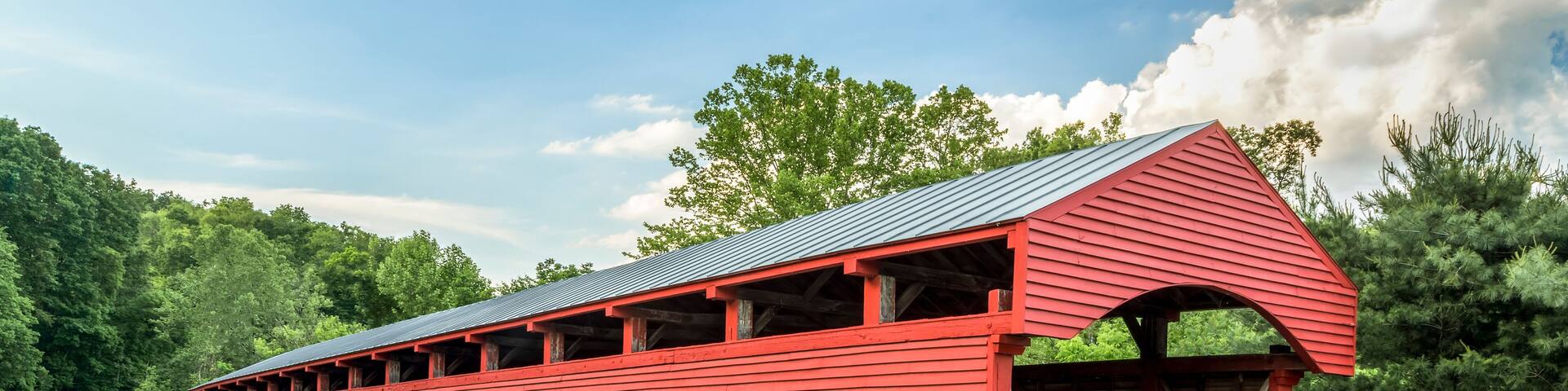 Built in 1853, the historic red Barrackville Covered Bridge crosses Buffalo Creek in Marion County, West Virginia not far from the city of Fairmont.