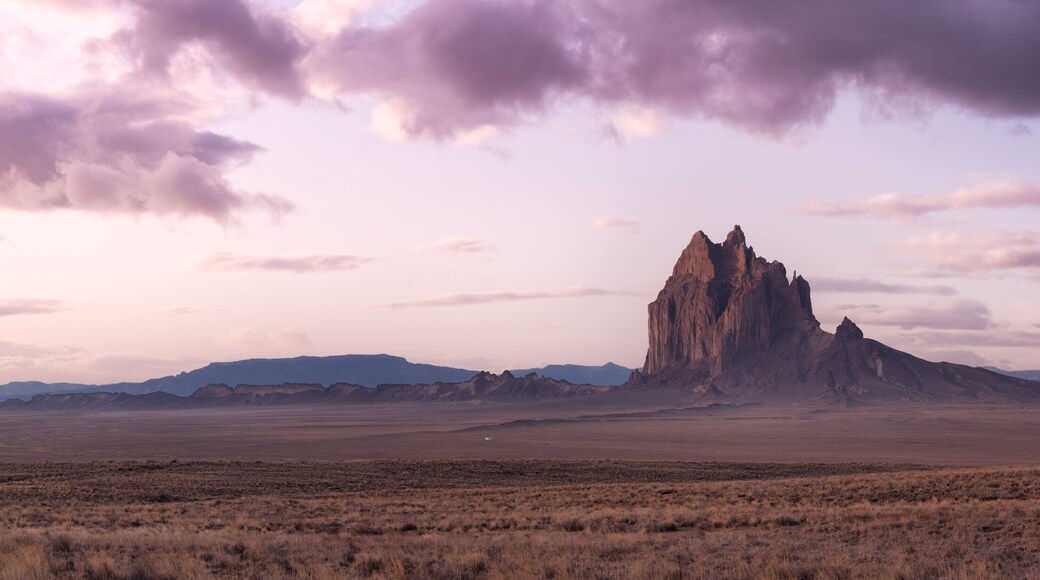 Panoramic American Nature Landscape View of the Dry Desert and Rugged Rocky Mountains. Colorful Sunrise Sky Art Render. Taken at Shiprock, New Mexico, United States.