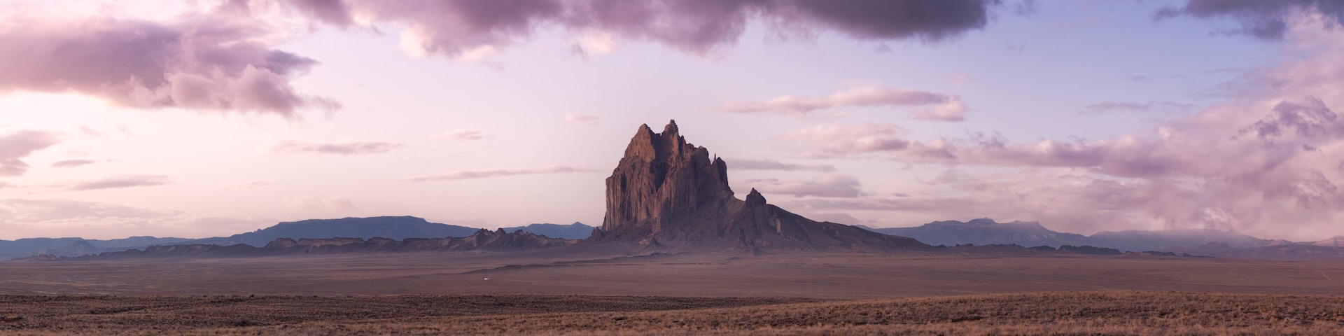 Panoramic American Nature Landscape View of the Dry Desert and Rugged Rocky Mountains. Colorful Sunrise Sky Art Render. Taken at Shiprock, New Mexico, United States.