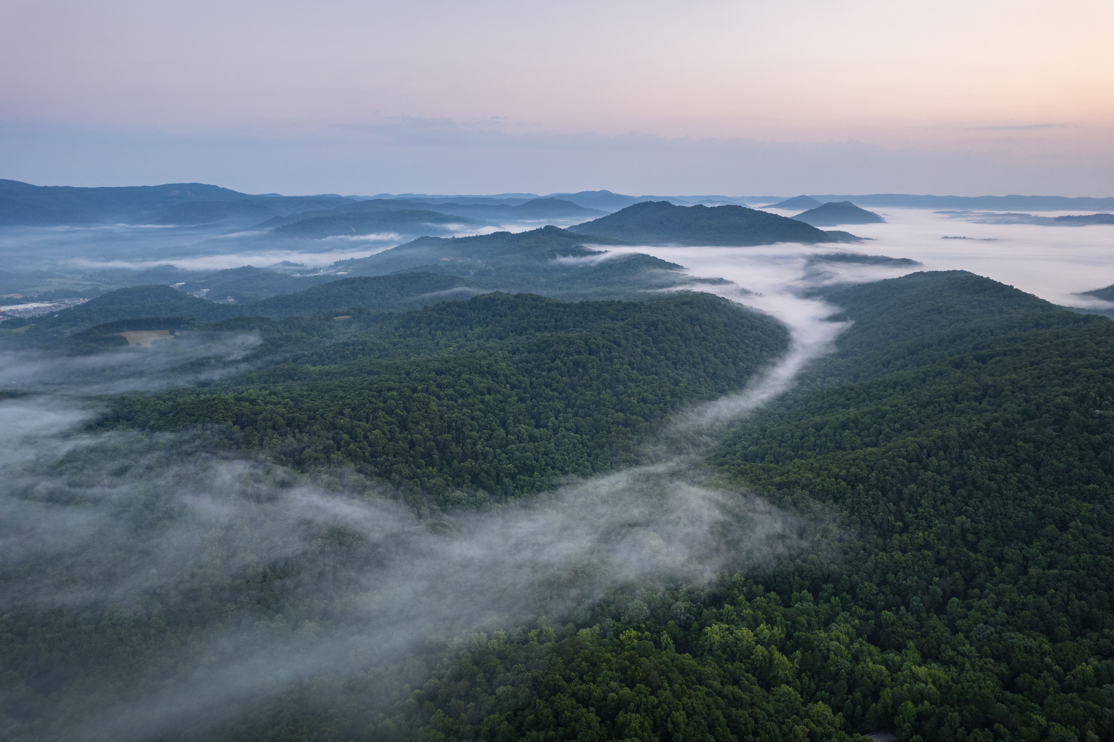 Un paysage montagneux, avec de vastes forêts et une vallée.