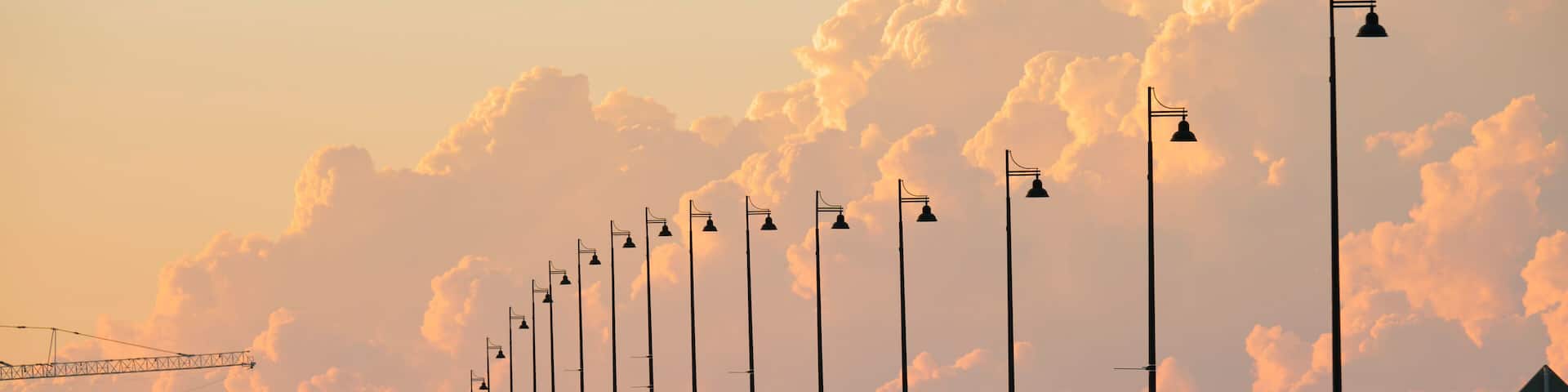 A bridge with street lamps and a water tower in the background.
