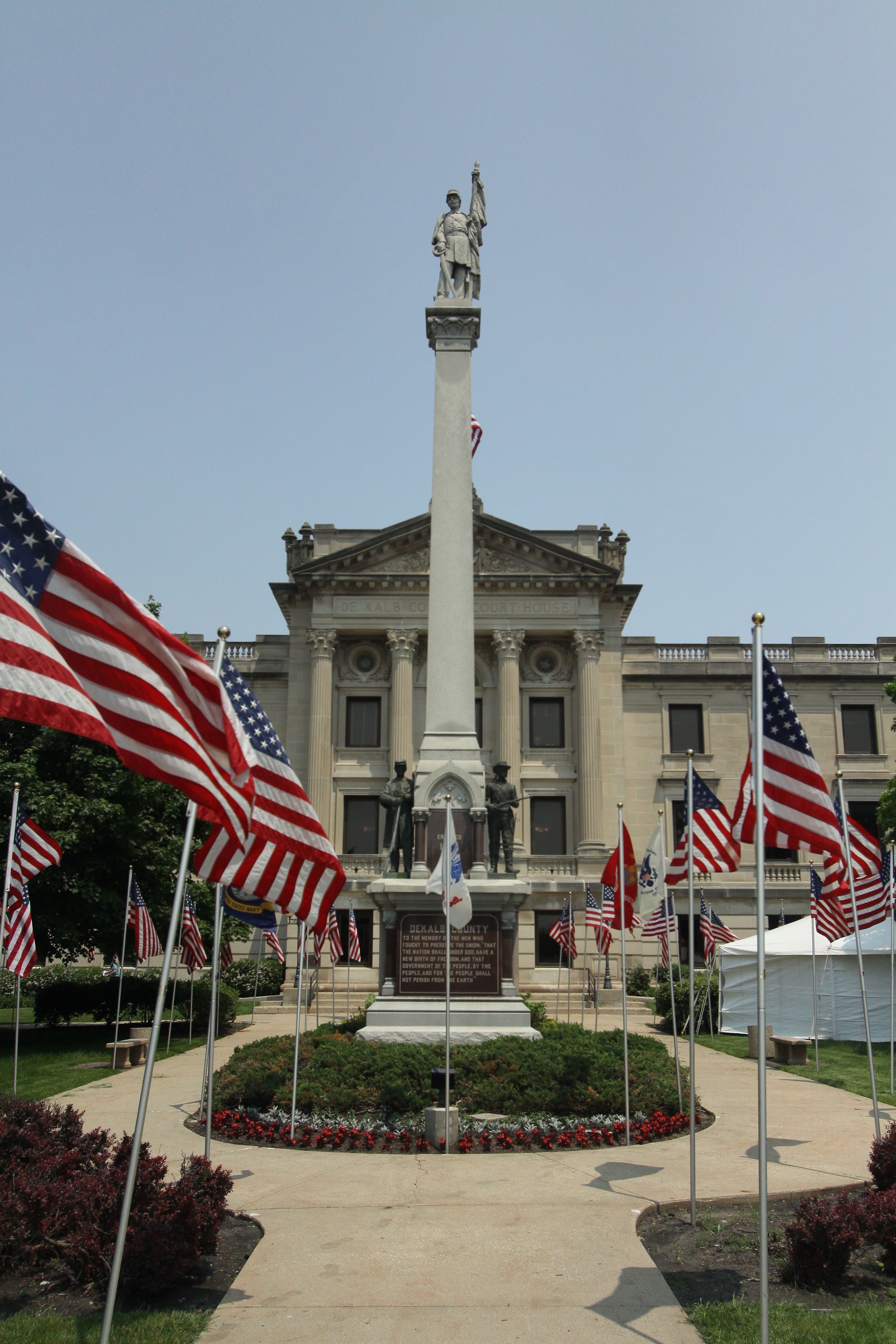 Ein Gerichtsgebäude mit einem zentralen Denkmal, umgeben von amerikanischen Flaggen.