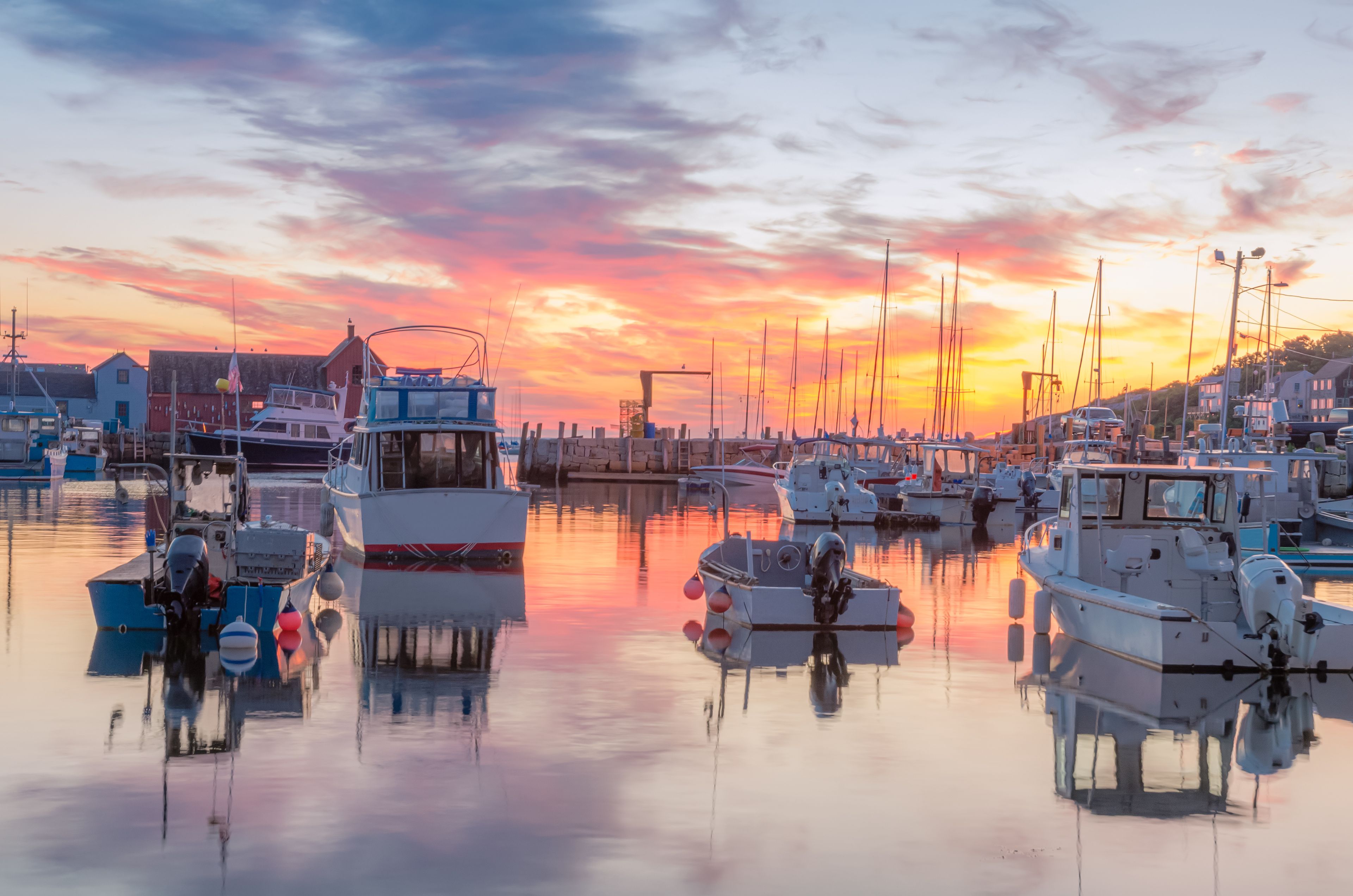 A marina with boats docked at sunset.