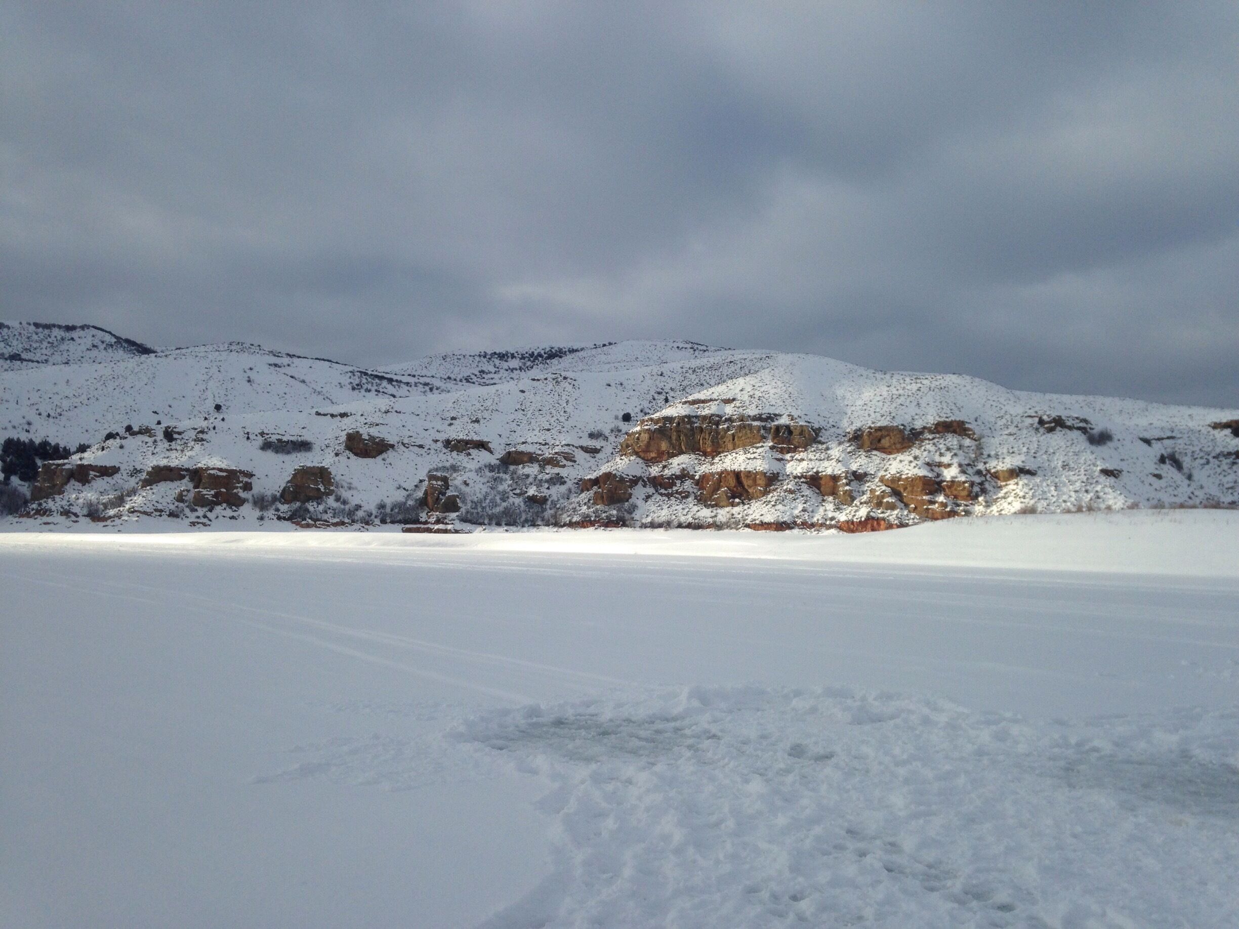 Sun hitting the cliffs in the middle of the storm. #ice #winter #snow