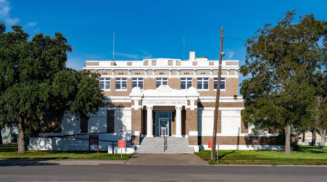 Un palacio de justicia con fachada blanca, detalles de ladrillo y una entrada central.