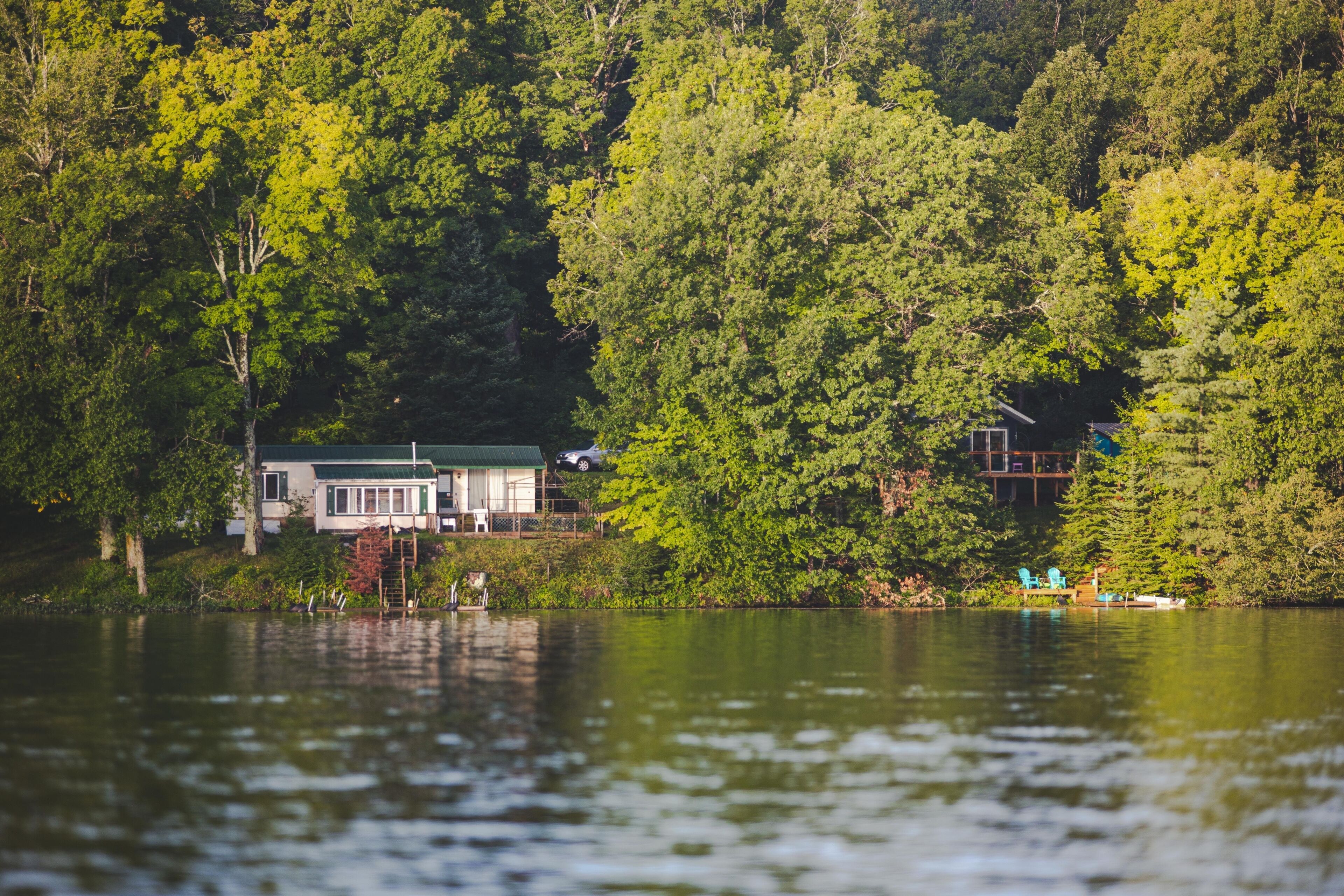 Scenic view of McClaine lake in Hayward, Wisconsin with green forest and a cabin in it