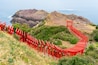 Motonosumi Inari Shrine with a long exposure in Yamaguchi Prefecture, Japan. 123 red torii gates aligned toward a seaside cliff overlooking the Japan Sea.