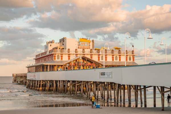 Daytona Beach Pier which includes general coastal views, a sunset and a sandy beach
