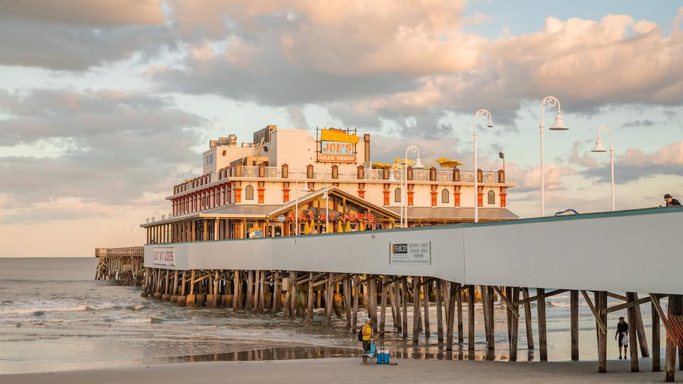 Daytona Beach Pier which includes general coastal views, a sunset and a sandy beach