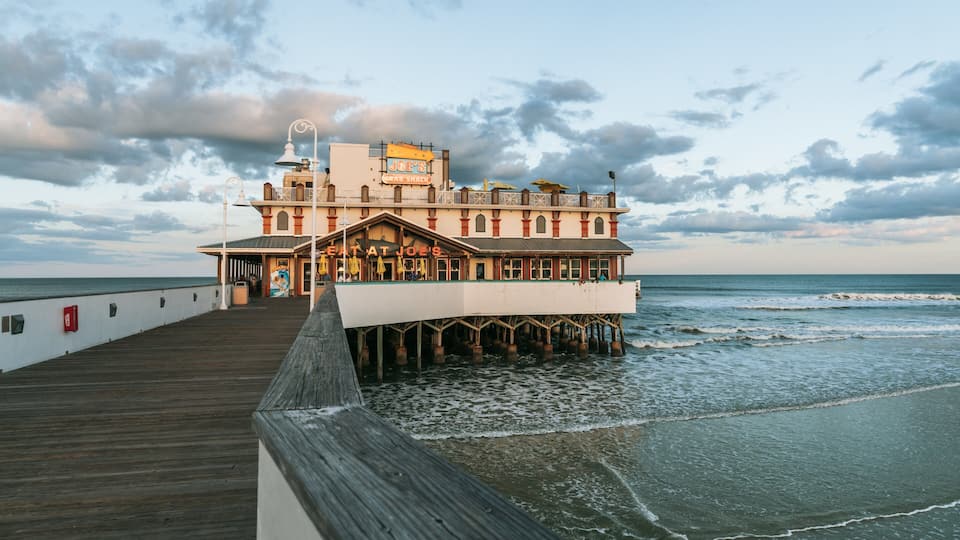 A pier leading to a waterfront restaurant named Joe's Crab Shack.