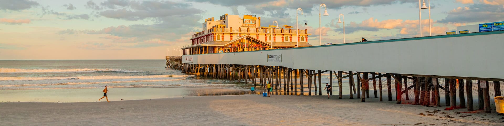 A beach with a pier and a building named "Joe's Crab Shack".