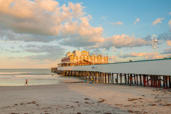 En strand med en mole og en bygning, der hedder "Joe's Crab Shack".