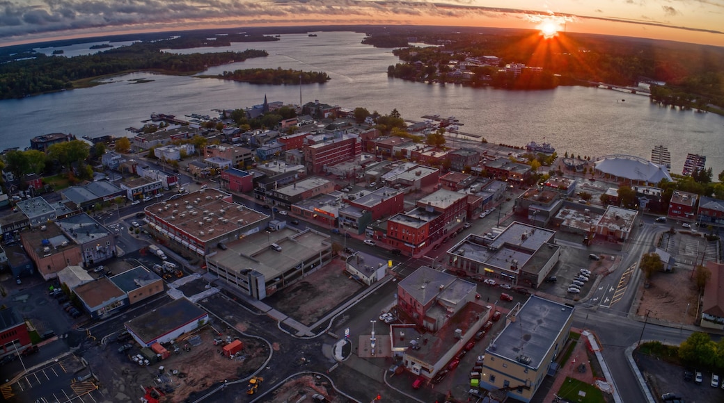 En kuststad i solnedgången, med en flod, industriella byggnader och en bro.