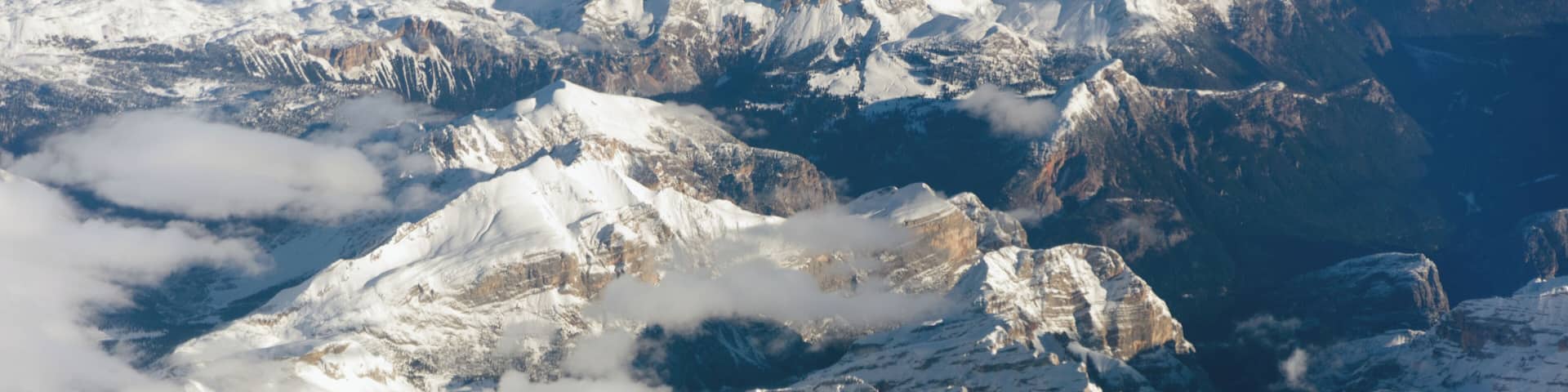 A snow-covered mountain range with rugged peaks and valleys.